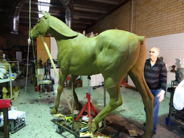 Master Sculptor Robert C Hitchcock standing next to a Life-Size Horse in his workshop. Bronze Sculpture by Artist and Master Sculptor Robert C Hitchcock
