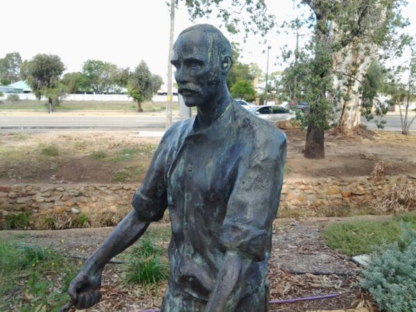 A statue of a man holding a baseball bat.