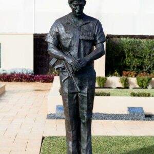 A bronze statue of a soldier holding a gun.