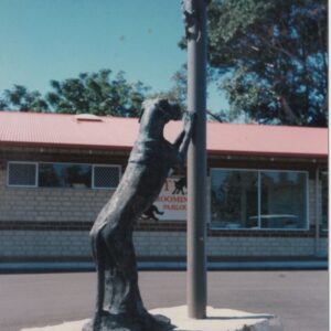 Bronze sculpture of a figure holding a pole in an outdoor setting. Sculptor - Robert C Hitchcock