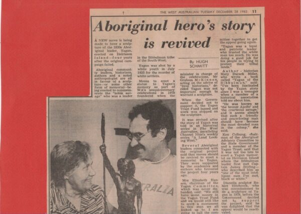 Old newspaper clipping featuring an article about an aboriginal hero with a photo of a smiling woman and man, the man wearing an "Australia" t-shirt, beside a bronze sculpture. Sculptor - Robert C Hitchcock