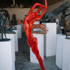 A collection of Red Bather sculptures by Master Sculptor Robert C. Hitchcock on display in a gallery. Bronze Sculpture by Artist and Master Sculptor Robert C Hitchcock