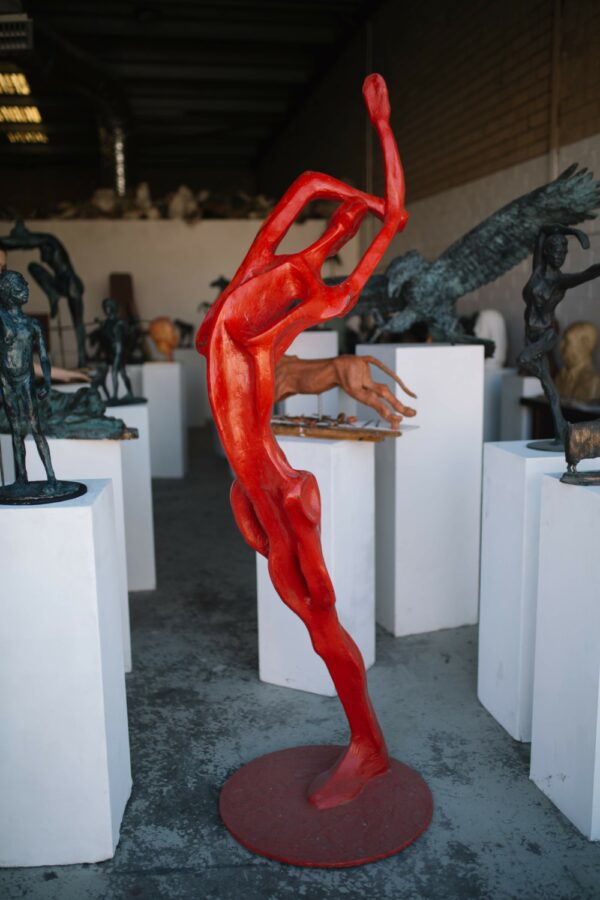A collection of Red Bather sculptures by Master Sculptor Robert C. Hitchcock on display in a gallery. Bronze Sculpture by Artist and Master Sculptor Robert C Hitchcock