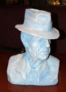 A blue bust of a man wearing a hat.